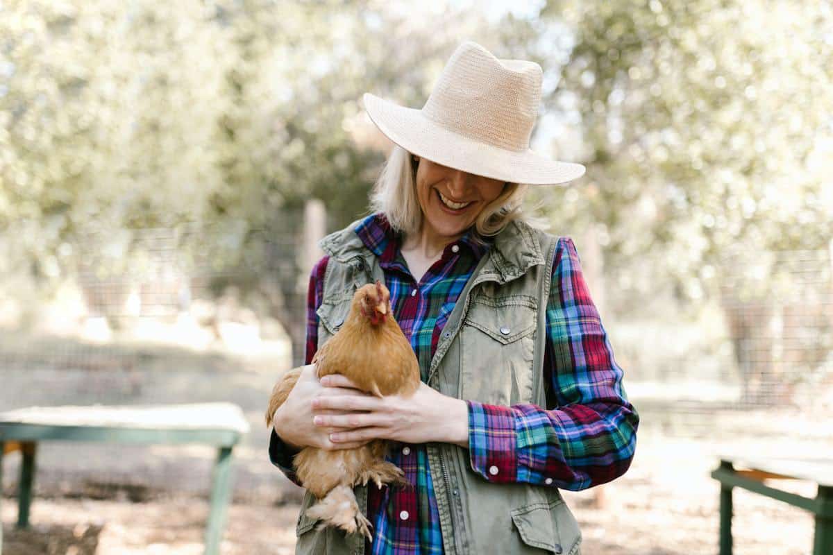 mulher segurando uma galinha